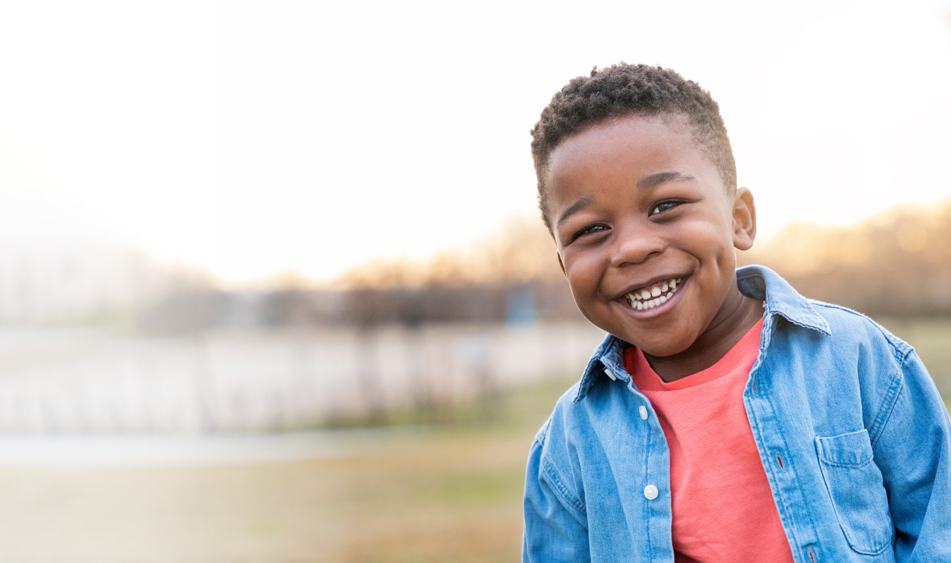 Young boy smiling in a field
